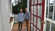Bargain hunter Dan (L) and real estate agent Nelson Taylor (R) take in the light-filled, window-paneled entryway with pretty red accents, as seen on HGTV's original series, Beachfront Bargain Hunt.