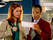 Die Stewardess (Lisa Summerour, re.) plaziert Beth (Stephanie Erb, li.) in der ersten Klasse, obwohl Beth nur die zweite Klasse gebucht hatte.