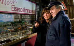 Man muss ja irgendwie im alten Bahnhof zusammenleben. Also versucht Helene (Gundi Ellert), mit Arthur (Andr&eacute; Jung) auszukommen. Zum Beispiel, indem sie seine alten Eisenbahnen geb&uuml;hrend bewundert.