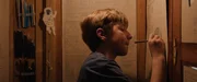 Tom (Theo Kretschmer) zeichnet auf der Innenseite seines Schrankes eine Weltkugel.