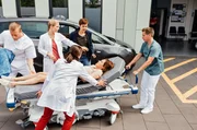 Tilda Sonnemann (Anja Thiemann, 2.v.r.) wird von ihrer Ehefrau Anne (Sandrine Mittelst&auml;dt, h.r.v.l.) in die Notaufnahme gebracht. Rebecca Krieger (Milena Straube, v.3.v.l.) und Julia Berger (Mirka Pigulla, 2.v.l.) k&uuml;mmern sich sofort um die Schwangere (mit Komparsen).