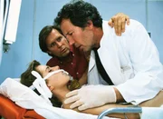 Dr. Stefan Frank (Sigmar Solbach, Mi.) und Chefarzt Dr. Ulrich Waldner (Hartmut Becker) k&uuml;mmern sich um den Notfall Vera Junghans (Karin Thaler).
