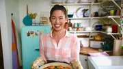 Portrait of Molly Yeh with her finished Spiced Beef Hot Dish With Bacon Jalapeno Cornbread, as seen on Girl Meets Farm, season 6.
