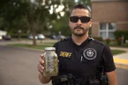 Der Polizeibeamte Jose M. Favela hält ein Glas mit Cannabis nach einer Beschlagnahmung.