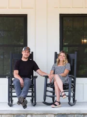 Sean Kilgore (left) and Sam Sutton sit on the front porch of their impecibly renovated 150-year-old farmhouse in rural Michigan.