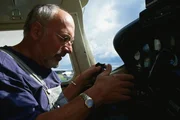 Das l&auml;sst Peter (Peter Lustig) sich nicht zweimal sagen. Er sitzt in einem Cockpit und betrachtet Kn&ouml;pfe und Hebel.