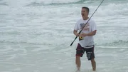 Homebuyer Tim laughs after a being knocked around by a big wave, as seen on HGTV's Beach Hunters.