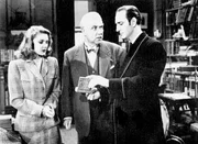 Basil Rathbone as Sherlock Holmes (r.), Eve Amber as Maude Fenwick, and Nigel Bruce as Dr. Watson