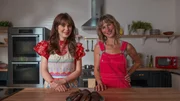 Zooey Deschanel and Jessie Sheehan with the Double Chocolate Malted Whoopie Pies, as seen on What Am I Eating? With Zooey Deschanel, Season 1. (posing)