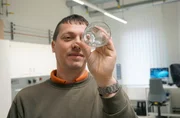 Erfinder Martin Gro&szlig; mit einem ausgeh&auml;rteten Trinkglas. Im Vergleich mit normalem Glas sind seine Gl&auml;ser viermal so fest