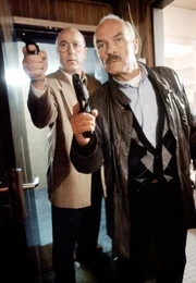 Kommissar Stoever (Manfred Krug, links) und sein Kollege Brockm&ouml;ller (Charles Brauer) in Hochspannung: vorsichtig dringen sie in die Wohnung des mutma&szlig;lichen M&ouml;rders ein.