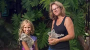 Izzie and Ali holding koalas smiling at the camera.