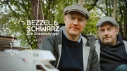 Key Visual Sendereihenbild mit Typo zu "Bezzel & Schwarz - Die Grenzg&auml;nger". Sebastian Bezzel (rechts) und Simon Schwarz (links), bekannt aus den Eberhoferkrimis, begeben sich auf Entdeckungstour in alle vier Himmelsrichtungen Bayerns. Dabei teilen sich die beiden Freunde ein Wohnmobil - Tag und Nacht - und treffen in jeder Folge auf spannende Grenzg&auml;ngerinnen und Grenzg&auml;nger: Menschen, die ihr Leben neu in die Hand genommen haben, sich f&uuml;r andere engagieren und ihrer Leidenschaft folgen.