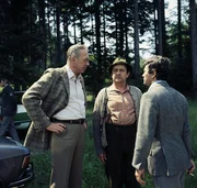 2. Fortstarbeiter Lohmann (Max Griesser, M.) berichtet den beiden Kripobeamten Derrick (Horst Tappert, l.) und Berger (Willi Sch&auml;fer, r.), dass er nach Entdeckung der Leiche die Polizei sofort verst&auml;ndigt hat.