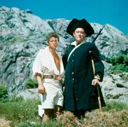 Die Suche nach dem Schatz ist John Silver's (Ivor Dean) große Stunde, auf die er jahrelang gewartet hat. Jim Hawkins (Michael Ande) bewundert den ungeheuren Willen und die Bärenkräfte des Einbeinigen. Die Suche nach dem Schatz ist John Silver's (Ivor Dean) große Stunde, auf die er jahrelang gewartet hat. Jim Hawkins (Michael Ande) bewundert den ungeheuren Willen und die Bärenkräfte des Einbeinigen.