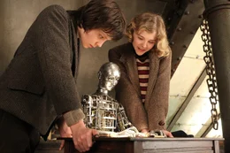 Kaum hat Hugo (Asa Butterfield, l.) mit Isabelles (Chloe Moritz, r.) Schl&uuml;ssel das Uhrwerk aufgezogen haben, setzt sich der Automat tats&auml;chlich in Bewegung und malt ein merkw&uuml;rdiges Bild: Es zeigt den Mann im Mond, dem gerade eine Rakete ins rechte Auge geflogen ist ...