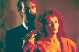 "Stirb langsam". Im Bild: Der Terrorist Gruber (Alan Rickman) nimmt Holly McClane (Bonnie Bedelia) als Geisel.