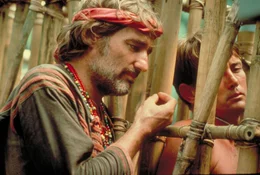 Ein Kriegsreporter (Dennis Hopper - links) versucht, so nah wie m&ouml;glich an Colonel Kurtz heranzukommen, wobei ihm Willard (Martin Sheen - rechts) helfen k&ouml;nnte. Daher hilft er Willard, frei zu kommen.