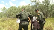 Laredo, TX: Two agents helping a woman walk. Laredo, TX: Two agents helping a woman walk.
