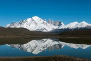 In der Amarga-Lagune spiegelt sich die schneebedeckte Bergkulisse; in der Mitte die drei Granittürme Torres del Paine (Türme des blauen Himmels). In der Amarga-Lagune spiegelt sich die schneebedeckte Bergkulisse; in der Mitte die drei Granittürme Torres del Paine (Türme des blauen Himmels).