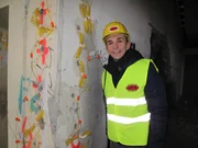 pur+-Moderator Eric Mayer vor einer mit Sprengs&auml;tzen pr&auml;parierten Wand.