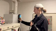 Rauchfangkehrerin Sophie misst die Werte an einer Heiztherme.