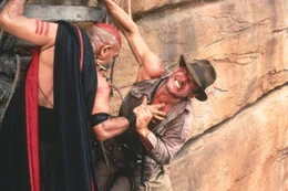 Mit Hilfe der schwarzen Magie der Todesg&ouml;ttin Shiva droht der b&ouml;se Hohepriester Mola Ram (Amrish Puri, l.), Indy (Harrison Ford, r.) das pochende Herz aus der Brust zu rei&szlig;en, um die heiligen Sankara Steine in seinen Besitz zu bringen ...