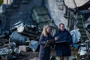Al Dickinson (played by Kurt Logan) compares findings with a fellow investigator at the site where United Express 6291 crashed into an industrial warehouse.