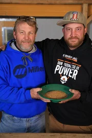 Rick Ness Senior and Rick Ness smiling holding gold pan
