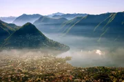 Morgendunst h&auml;ngt &uuml;ber der Tessiner Stadt Lugano.