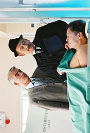 Felix (Christoph M. Ohrt, l.) und Bestatter Paulsen (Tilo Pr&uuml;ckner, r.) betrachten den toten Horst Windeck (Jockel Tschiersch, liegend).