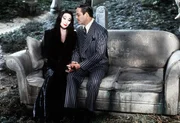 Mutter Morticia (Anjelica Huston, l.) und Vater Gomez (Raul Julia, r.) pflegen eine innige Liebesbeziehung. Auf dem Friedhof besprechen sie die derzeitigen Familienereignisse ...