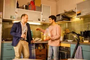 Yannik (Rojan Juan Barani, r.) bietet Sven (Sven Daniel B&uuml;hler, l.) Toast an, w&auml;hrend Sven ihm etwas Wichtiges zu sagen hat.