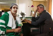Staller (Helmfried von L&uuml;ttichau) setzt sich mit orangefarbener Feuchtigkeitsmaske und Cocktail zu Robert Jung (Markus B&ouml;ker, rechts) an die Bar. Robert Jung erz&auml;hlt ihm, dass sich Ute komisch benimmt und er sich nicht mehr sicher ist, ob er mit ihr die Beziehung weiterf&uuml;hren m&ouml;chte.