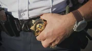 Deputy Marcus Martinez hält seine Dienstmarke Deputy Marcus Martinez hält seine Dienstmarke
