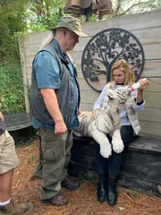 Myrtle Beach, SC- Mariana van Zeller holds a tiger cub and talks with Myrtle Beach Safari founder Bhagavan "Doc" Antle. (Credit: National Geographic/Muck Media)