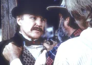 Edwards (Victor French, M.) und Almanzo (Dean Butler, r.) wollen von Dr. McQueen (Anthony Zerbe, l.) wissen, warum er den jungen Matthew wie ein Tier in einem Käfig hält. Edwards (Victor French, M.) und Almanzo (Dean Butler, r.) wollen von Dr. McQueen (Anthony Zerbe, l.) wissen, warum er den jungen Matthew wie ein Tier in einem Käfig hält.