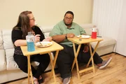 Brandon and his girlfriend are eating on a couch. Brandon and his girlfriend are eating on a couch.
