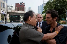 Vor den Augen von Manager Dwight Cochrane (Ulrich Tukur, M.) attackiert Largo Winch (Tomer Sisley, r.) einen thail&auml;ndischen Beamten (Komparse).