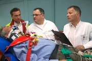 Nachdem Arzus Mutter &uuml;berraschend in Leipzig vor der T&uuml;r ihrer Tochter stand, wird in die Sachsenklinik vom Notarzt (Markus Neumann, li.) ein Verletzter nach einem Autounfall eingeliefert. Dr. Roland Heilmann (Thomas R&uuml;hmann, re.) und Pfleger Hans-Peter Brenner (Michael Trischan, mi.) erkennen ihn sofort - Arzus Vater Klaus Ritter (Rolf Kanis, liegend).