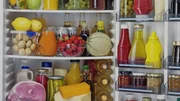 Das Bild zeigt das Innere eines K&uuml;hlschranks, gef&uuml;llt mit verschiedenen Lebensmitteln und Getr&auml;nken. Auf den Regalen befinden sich Obst, Gem&uuml;se, Milchprodukte, S&auml;fte, Gew&uuml;rze und Flaschengetr&auml;nke, was die Funktion des K&uuml;hlschranks zur Frischebewahrung verdeutlicht.