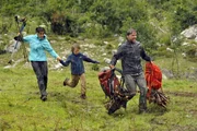 Die Familie Wedekind (Katrin Ritt, Vincent Mauz, Patrick Back) eilt durch das Unwetter zu den gerade eintreffenden Fahrzeugen der Bergwacht.