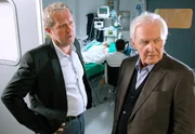 Nach dem schrecklichen Autounfall liegt Claudia (Susanne Michel, im Hintergrund) im Koma. Thomas (Harald Krassnitzer, links) verd&auml;chtigt den behandelnden Arzt einer unzureichenden Behandlung. Er teilt Gottfried (Wolfgang H&uuml;bsch, rechts) mit, wie kritisch Claudias Zustand ist.