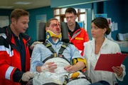 Im EKH übergibt Dr. Haase (Fabian Harloff, l.) den verunfallten Andreas Wagner (Niels Bruno Schmidt, M.) an Dr. Jonas (Gerit Kling, r.).