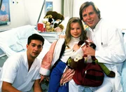 Umsorgt von Dr. Stefan Frank (Sigmar Solbach, r.) und Julian (Andreas Elsholz) f&uuml;hlt sich das Waisenkind Iris (Jana Kilka) wohl.