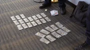 Mehrere Geldstapel wurden auf den Boden gelegt, nachdem sie in den Sachen eines Passagiers in Dulles, Virginia, entdeckt worden waren.