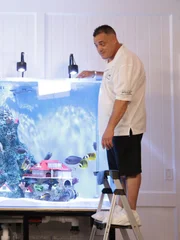 Wayde puts the fish in the tank.