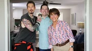 From left to right: Host David Bromstad, Hayden Balgavy, and Jane Balgavy pose for a picture in House 3, Dandelion Drop, as seen on My Lottery Dream Home, Season 16.
