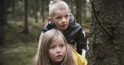 Robin (Erlend B&ouml;e) und Kaja (Synne Stensg&aring;rd) beobachten, wie im Wald ein Gewehr versteckt wird.