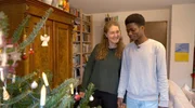Nora und Raphael schm&uuml;cken den Baum an Heilig Abend.